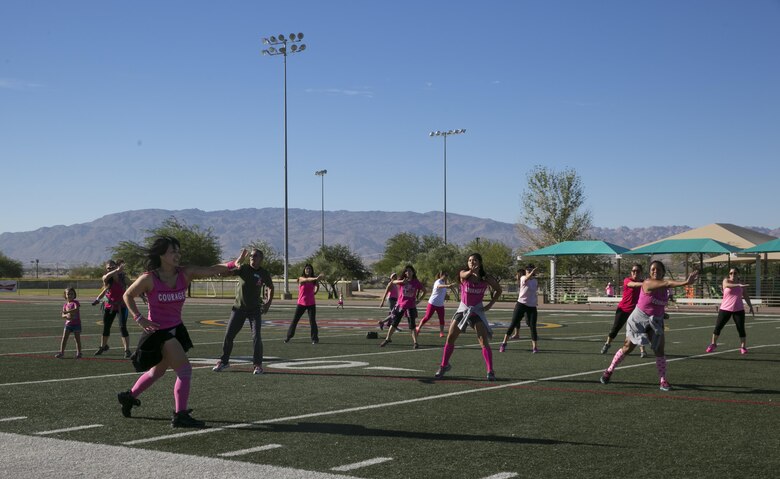 Combat Center patrons participate in Zumba during the Officers' Spouses' Club third annual Pink Breast Cancer Awareness Walk at Felix Field aboard the Marine Corps Air Ground Combat Center, Twentynine Palms, Calif., Oct. 14, 2016. OSC hosted the walk to raise awareness and money for breast cancer research. (Official Marine Corps photo by Lance Cpl. Dave Flores/Released)