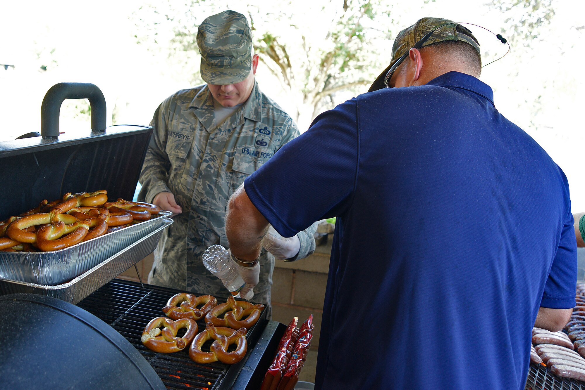 U.S. Air Force Master Sgt. David Humphreys, 18th Weather Squadron manager of U.S. Army Central weather plans and requirements, and Master Sgt. Aaron Bunyea, 609th Air Communications Squadron first sergeant, prepare food during an “Oktoberfest” event at Memorial Lake at Shaw Air Force Base, S.C., Oct. 20, 2016. Team Shaw’s Diamond Council expressed their appreciation for the work Team Shaw Airmen do every day by providing a free Oktoberfest-themed lunch. (U.S. Air Force photo by Airman 1st Class BrieAnna Stillman)  
