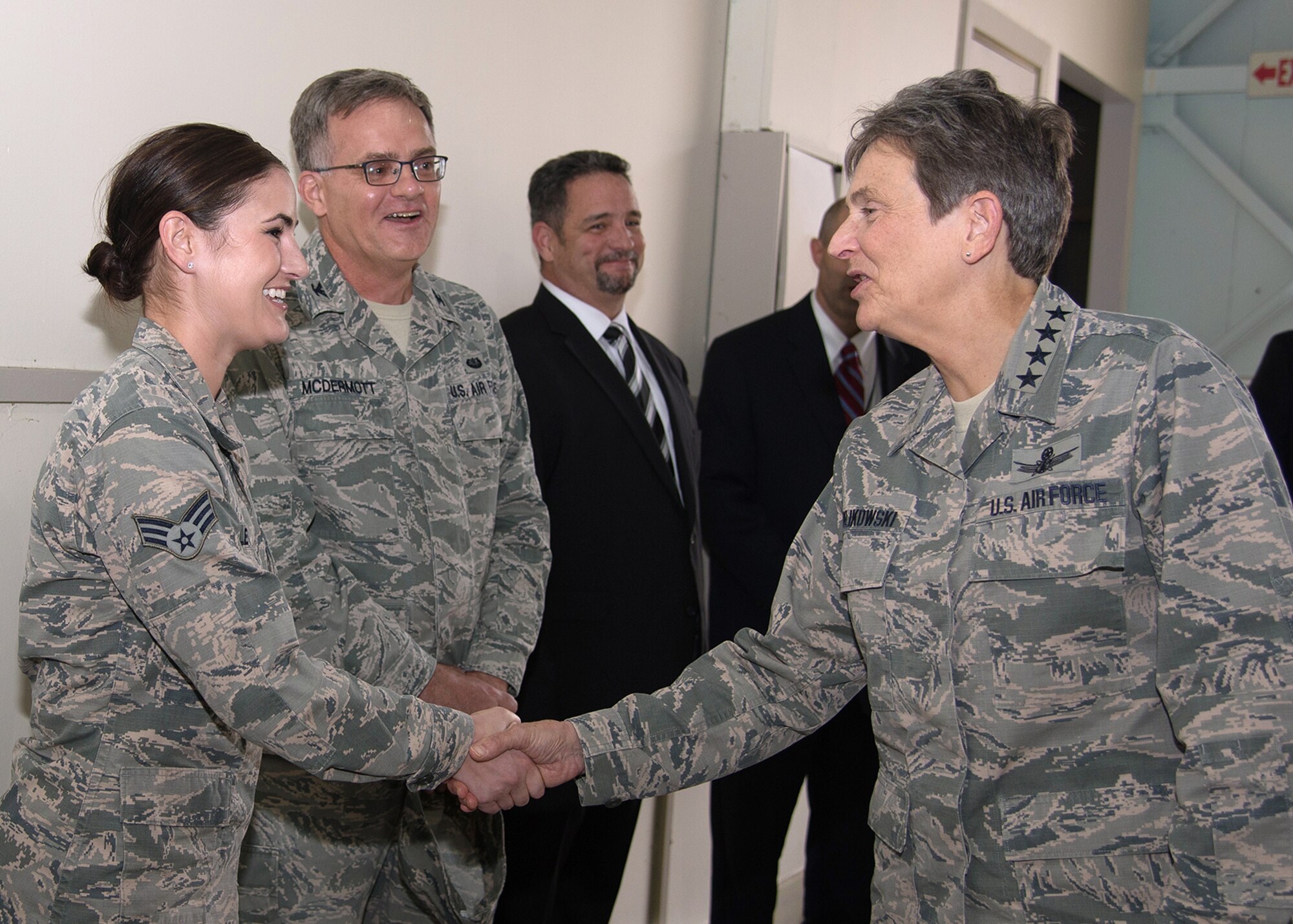 Gen. Ellen M. Pawlikowski, commander of Air Force Materiel Command, presents a coin to Senior Airman Kelly Pletz, a paralegal with the 66th Air Base Group, during a visit to Hanscom Air Force Base, Mass., Oct. 21, as Col. Richard J. McDermott, 66th Air Base Group staff judge advocate, and others look on. While at Hanscom, Pawlikowski met with Hanscom program executive officers, participated in a Revolutionary Acquisition Techniques Procedures and Collaboration, or RATPAC, panel discussion and toured the installation. (U.S. Air Force photo by Mark Herlihy)