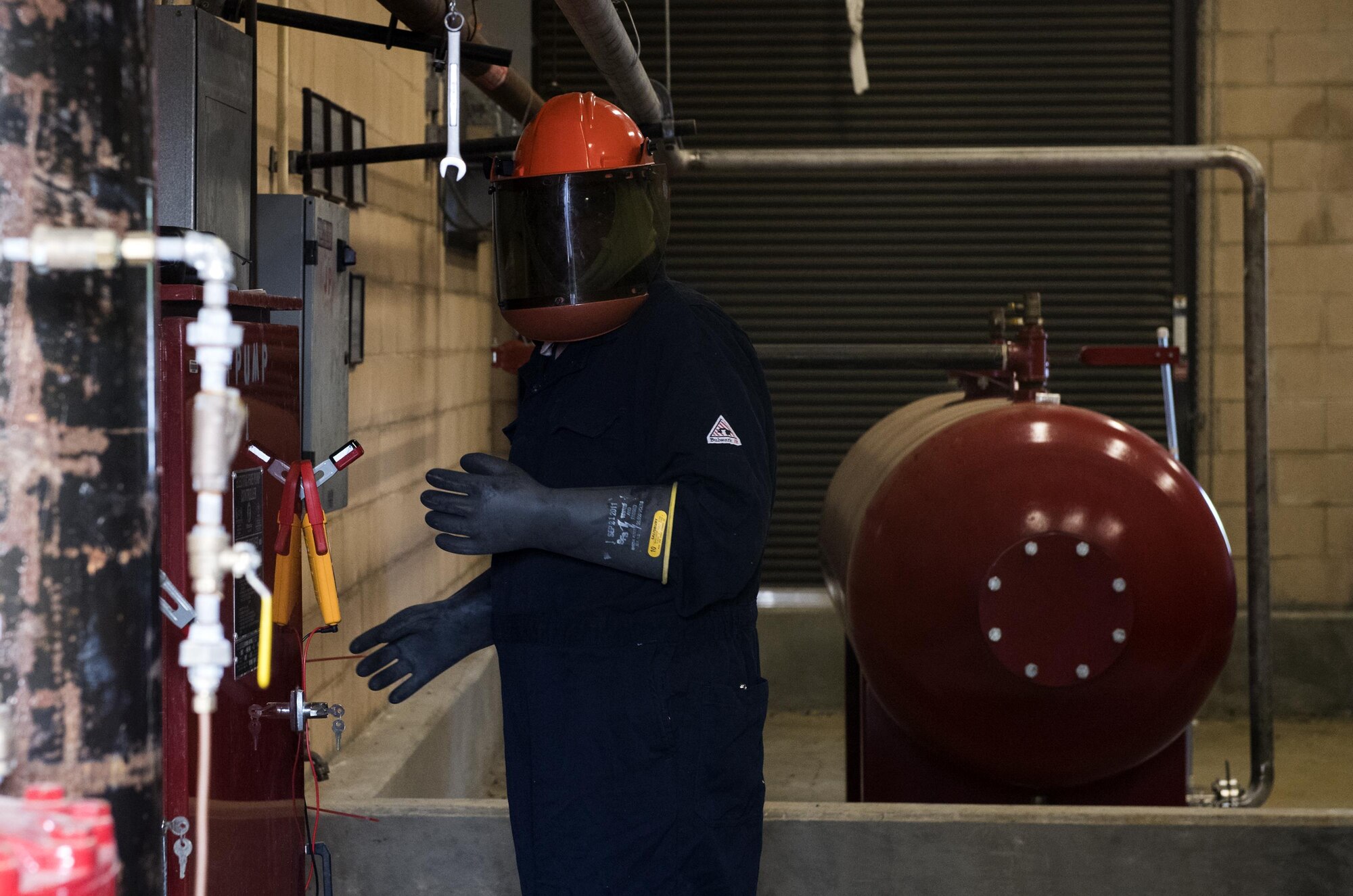 Tim Jacobs, contracted senior inspector, ensures the room is clear before an inspection, Oct. 25, 2016, at Moody Air Force Base, Ga. Jacobs wore grounding equipment while testing the electrical components of the foam pump system. A charge as small as the static electricity on clothing can spark a deadly volt from the system which takes 4800 volts of electricity to power. (U.S. Air Force photo by Airman 1st Class Janiqua P. Robinson) 