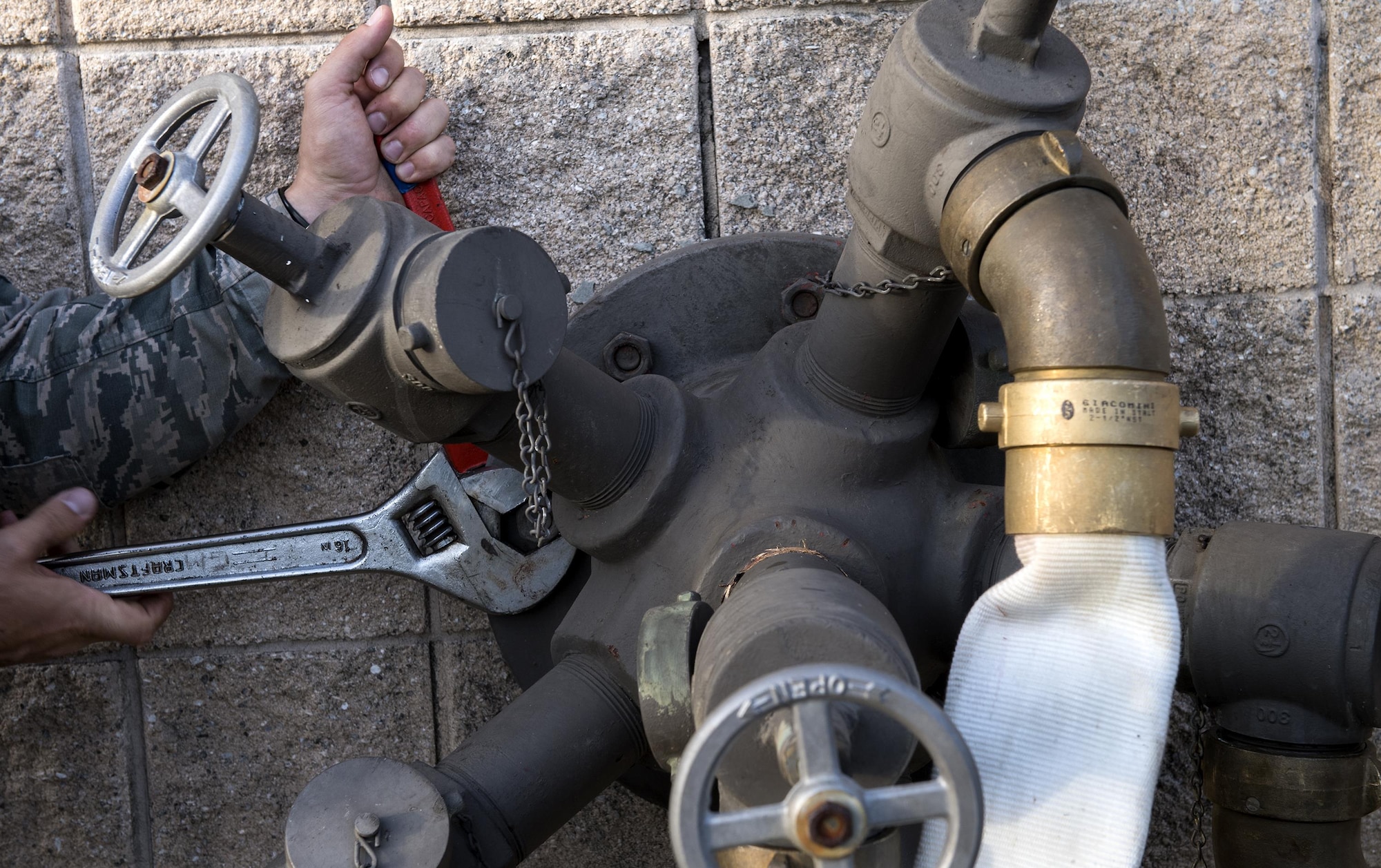 Airmen from the 23d Civil Engineer Squadron tighten bolts to secure a fire hose pump-spigot, Oct. 25, 2016, at Moody Air Force Base, Ga. Every five years, contractors come to Moody to perform a flow test, which ensures the pumps are producing the correct number of gallons of water per minute that translates to the correct pounds per square inch of fire-fighting foam. (U.S. Air Force photo by Airman 1st Class Janiqua P. Robinson)