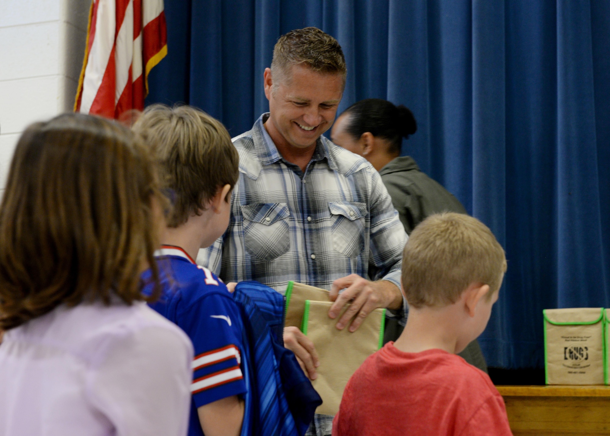 Christopher Baumgardner, 97th Wing Staff Agency Drug Demand Reduction program manager, hands out goodie bags to children at L. Mendel Rivers Elementary School, Oct. 24, 2016, Altus Air Force Base, Okla. DDR is working with the local community to help raise awareness of drug and alcohol abuse. (U.S. Air Force Photo by Airman Jackson N. Haddon/Released).