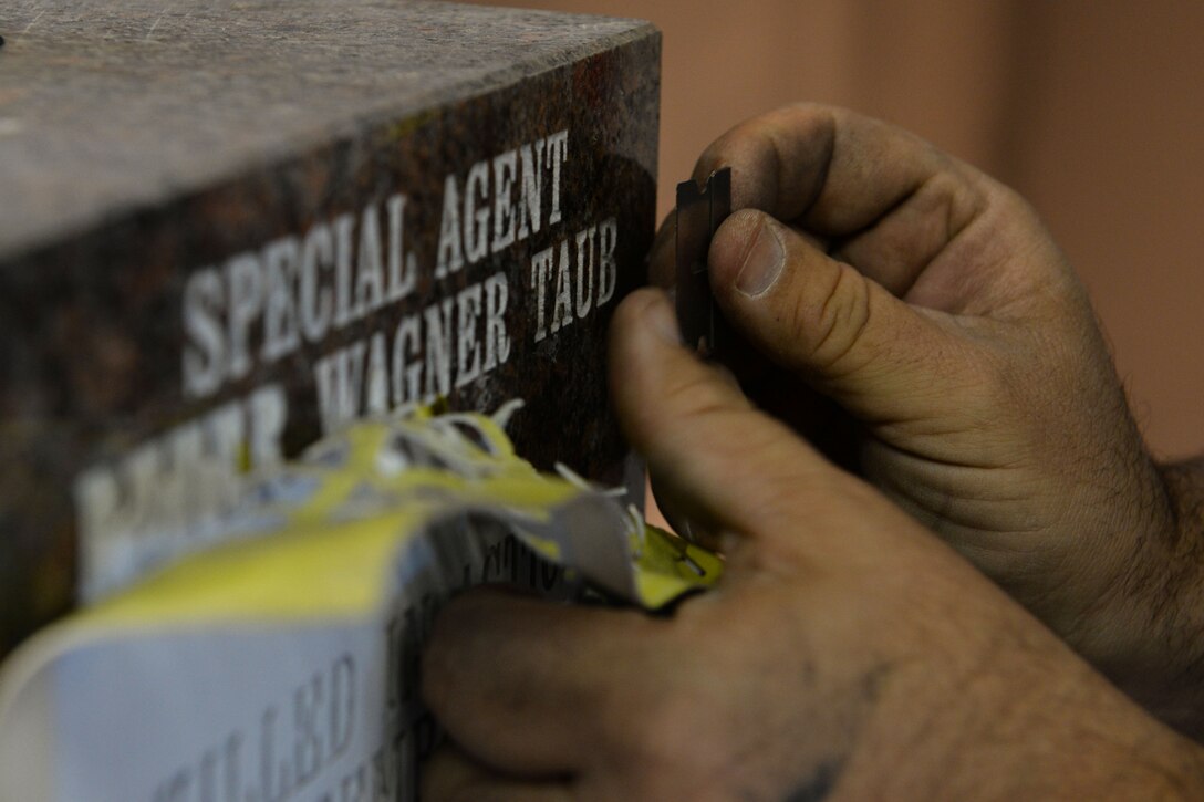 Mark Luken, an engraver at West River Monument Company, removes a stencil on a memorial monument in Rapid City, S.D., Oct. 18, 2016. This monument was donated by the Rapid City Chamber of Commerce in honor of Special Agent Peter Taub, an Air Force Office of Special Investigations agent who was killed in action near Bagram Airfield, Afghanistan Dec. 21, 2015. (U.S. Air Force photo by Senior Airman Rebecca Imwalle)
