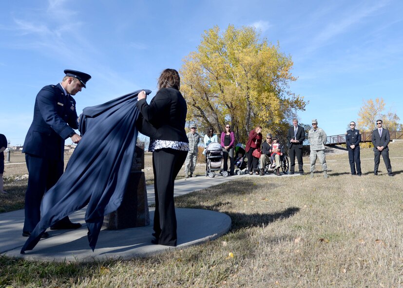 Special Agent Christopher Joers, Air Force Office of Special Investigations Agent assigned to 28th Bomb Wing, and Lynn Kendall, vice president of the Rapid City Chamber of Commerce, unveil a memorial for SA Peter Taub, during a ceremony at Ellsworth Air Force Base, S.D., Oct. 21, 2016. Family, friends and fellow AF OSI Agents came from across the country to attend the ceremonies that honored the sacrifice of Taub, AFOSI agent that was assigned to the 28th BW who was killed in action Dec. 21, 2015. (U.S. Air Force photo by Senior Airman Rebecca Imwalle)