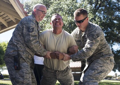 Senior Airman Christian Torres, Joint Base San Antonio-Randolph Fire Emergency Services firefighter, volunteers for a taser demonstration during the Battle of the Badges competition at Eberle Park on JBSA-Randolph Oct. 22, 2016. The 902nd Security Forces Squadron “Defenders” and the JBSA-Randolph FES “Fire Dawgs” face off annually in Battle of the Badges and conduct demonstrations such as a taser, live fire, auto-extrication and military working dog demos.