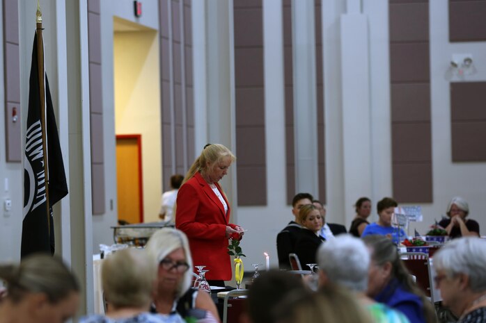 Retired Marine Corps Sgt. Maj. Holly Prafke, co-chair of the 2016 Salute to Women of the Military event, presents the prisoner of war/missing in action table at the Tourist and Event Center in Havelock, N.C., Oct. 20, 2016. In 1987, Bee Mayo and Jean Nelson first discussed the idea of recognizing contributions made by women in the military. Today, that legacy lives on in the Eastern North Carolina area through the Salute to Women of the Military. The event continues to identify women as a vital part of the U.S. Armed Forces. Women from all branches of the military who served in the past or are currently serving came to support the occasion. Mayo is a board member of the Craven County Council on Women, and Nelson is the regional director for the NC Council for Women. (U.S. Marine Corps photo by Lance Cpl. Mackenzie Gibson/Released)