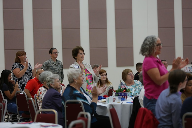 Attendees of the 2016 Salute to Women of the Military event applaud their service song as it plays at the Tourist and Event Center in Havelock, N.C., Oct. 20, 2016. In 1987, Bee Mayo and Jean Nelson first discussed the idea of recognizing contributions made by women in the military. Today, that legacy lives on in the Eastern North Carolina area through the Salute to Women of the Military. The event continues to identify women as a vital part of the U.S. Armed Forces. Women from all branches of the military who served in the past or are currently serving came to support the occasion. Mayo is a board member of the Craven County Council on Women, and Nelson is the regional director for the NC Council for Women. (U.S. Marine Corps photo by Lance Cpl. Mackenzie Gibson/Released)