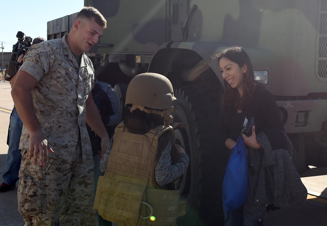 U.S. Marine Cpl. Jacob Rouse, Detachment-1, Motor Transport Maintenance Company, helps participants of Operation Dyess Kids try on helmets and body armor at Dyess Air Force Base, Texas. During this event, children participated in a mock deployment to get an understanding of what it is like when their parents deploy. (U.S. Air Force photo by Staff Sgt. Kia Atkins)