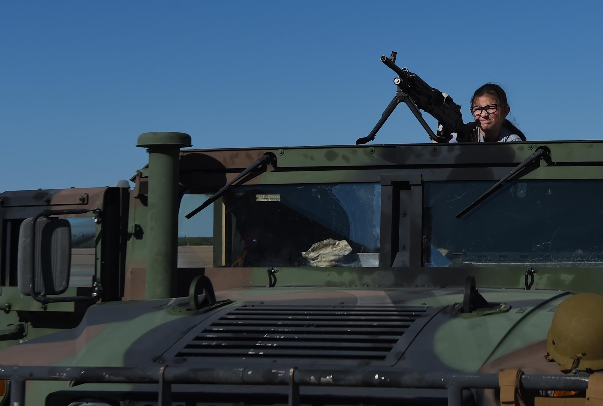 Kylee Barnes, Operation Dyess Kids 2016 participant, looks down the sights of an M240 Bravo medium machine gun mounted to a Humvee at Dyess Air Force, Base, Oct. 22, 2016. During the event, several units from around Dyess had displays to show the children different career fields in the Air Force, such as explosive ordnance disposal, K-9 handlers and firefighters. (U.S. Air Force photo by Staff Sgt. Kia Atkins)