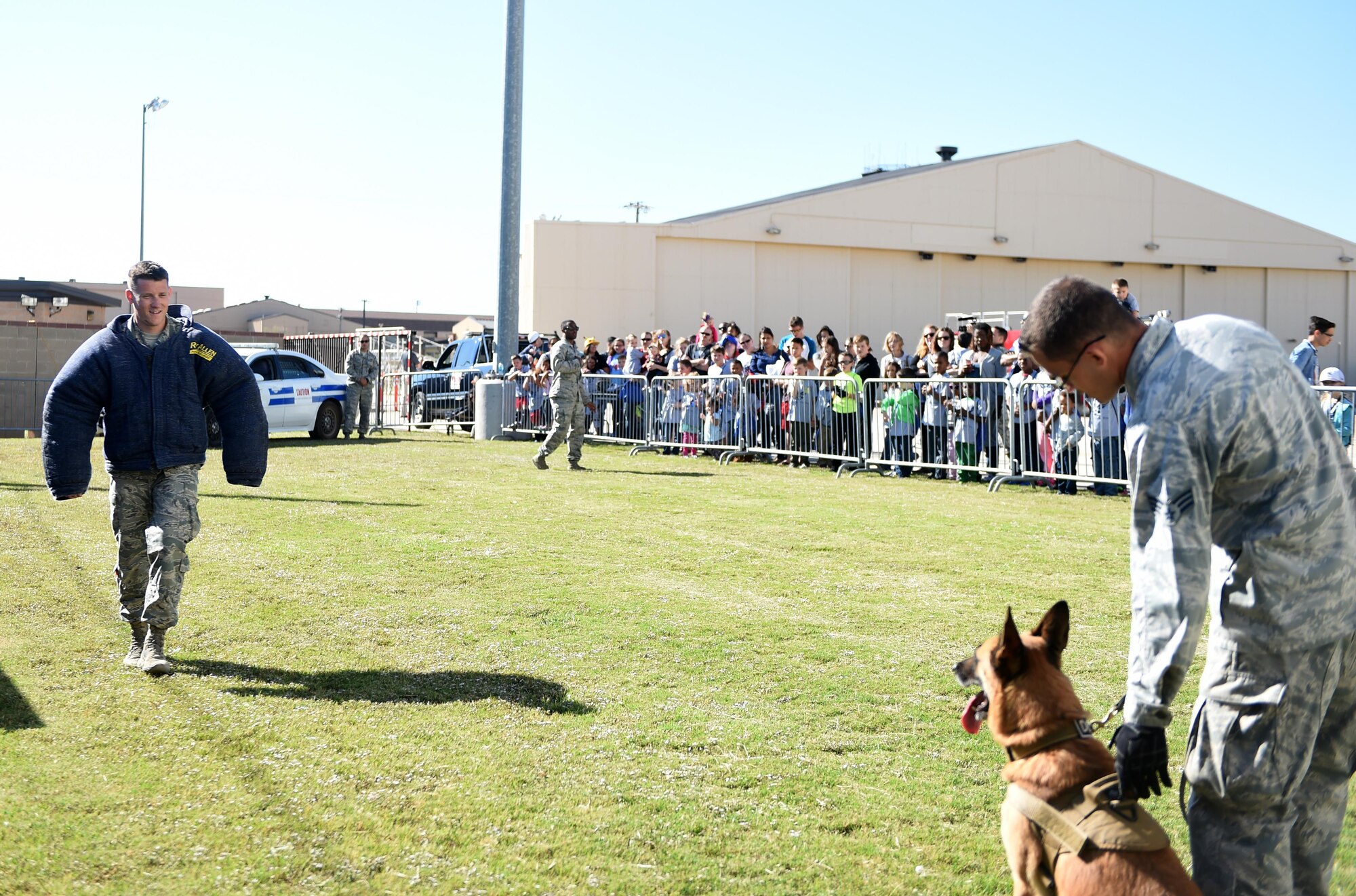 Participants of Operation Dyess Kids 2016 watch a demonstration from the 7th Security Forces Squadron military working dogs at Dyess Air Force Base, Texas, Oct. 22, 2016. After going through a mock deployment line and receiving a pre-deployment brief, the children were also shown static displays from various units around base. (U.S. Air Force photo by Staff Sgt. Kia Atkins)