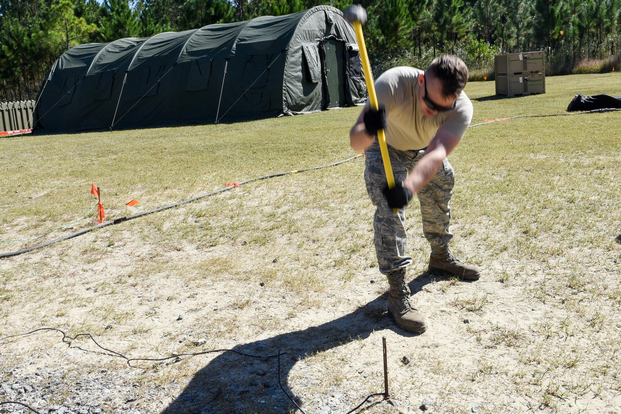An Air Commando with the 1st Special Operations Civil Engineer Squadron, hammers a grounding rod in the ground during the construction of a Joint Special Operations Air Detachment at the Gulfport-Biloxi International Airport in Gulfport, Miss., Oct. 22, 2016. The 1st Special Operations Wing is participating in Exercise Southern Strike to practice tactical skills and test the capabilities of its Airmen and assets in a deployed environment. (U.S. Air Force photo by Senior Airman Jeff Parkinson)