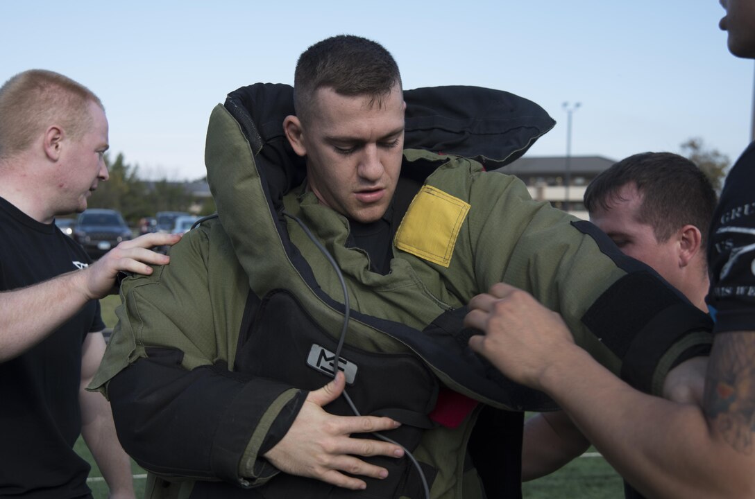 Senior Airman Brandon Thompson, 11th Security Forces Squadron security forces member, receives help from teammates while putting on an explosive ordinance disposal suit during the Battle of the Badges at Joint Base Andrews, Md., Oct. 21, 2016. Battle of the Badges is a competition between JBA’s emergency response teams held to bring the emergency units together and build camaraderie through friendly competition. (U.S. Air Force photo by Airman 1st Class Rustie Kramer) 
