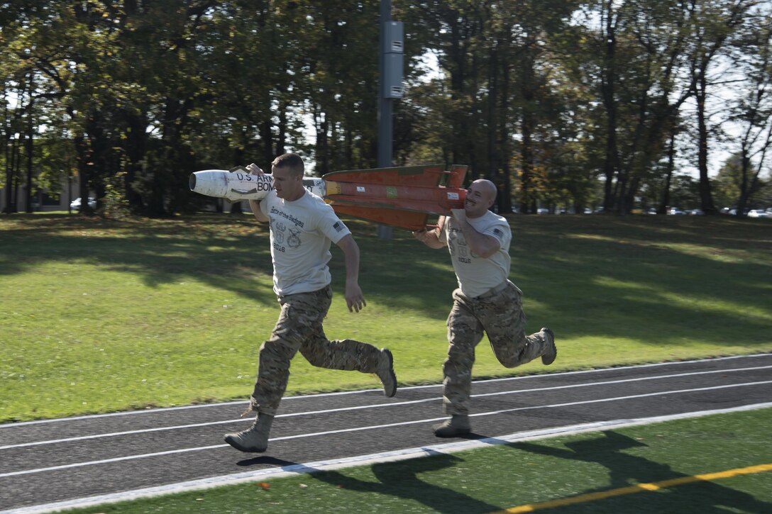 Staff Sgt. Courtney Corral and Staff Sgt. Gerald Kelley, 11th Security Support Squadron run with an explosive ordinance disposal training device during the inaugural Battle of the Badges at Joint Base Andrews, Md., Oct. 21, 2016. Teams of four ran a half-mile with two people carrying the EOD training device while the other two teammates ran behind them; the teams were allowed to switch the device between members but could not allow it to drop below their knees. (U.S. Air Force photo by Airman 1st Class Rustie Kramer) 
