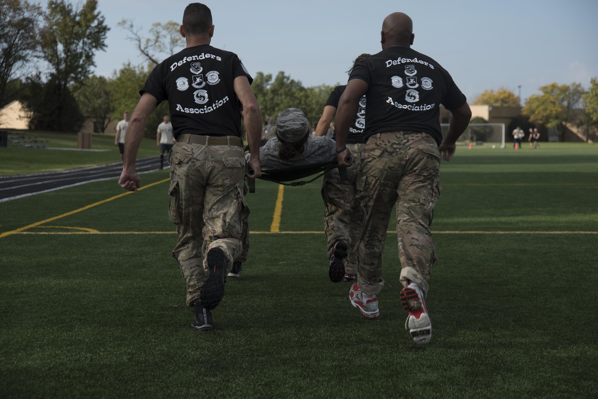 Airman 1st Class Amanda Sierras, 779th Medical Operations Squadron emergency medical technician, is carried by a team from the 11th Security Forces Group antiterrorism office during the inaugural Battle of the Badges at Joint Base Andrews, Md., Oct. 21, 2016. Nine teams competed in timed events including a litter carry, dummy drag, weapons assembly and half-mile run while holding an explosive ordinance disposal training device.  (U.S. Air Force photo by Airman 1st Class Rustie Kramer) 

