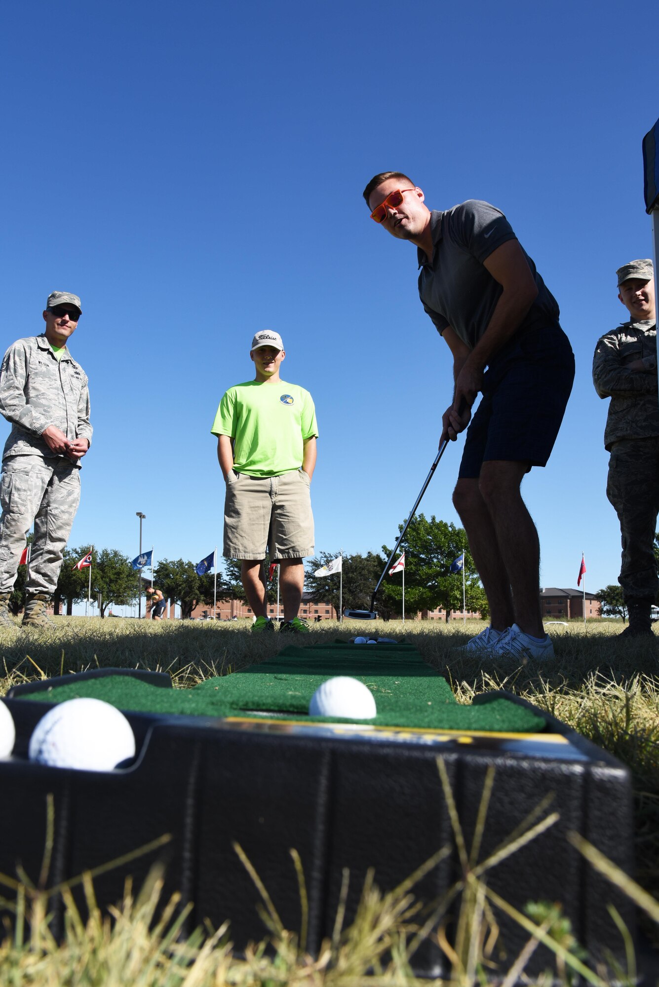 U.S. Air Force Senior Airman Alex Harris, 17th Contracting Squadron contract administrator, sinks a putt during the Make Goodfellow Great Trucktoberfest event at the parade grounds on Goodfellow Air Force Base, Texas, Oct. 21, 2016. Golfing is one of the clubs offered at Goodfellow. (U.S. Air Force photo by Senior Airman Joshua Edwards/Released)