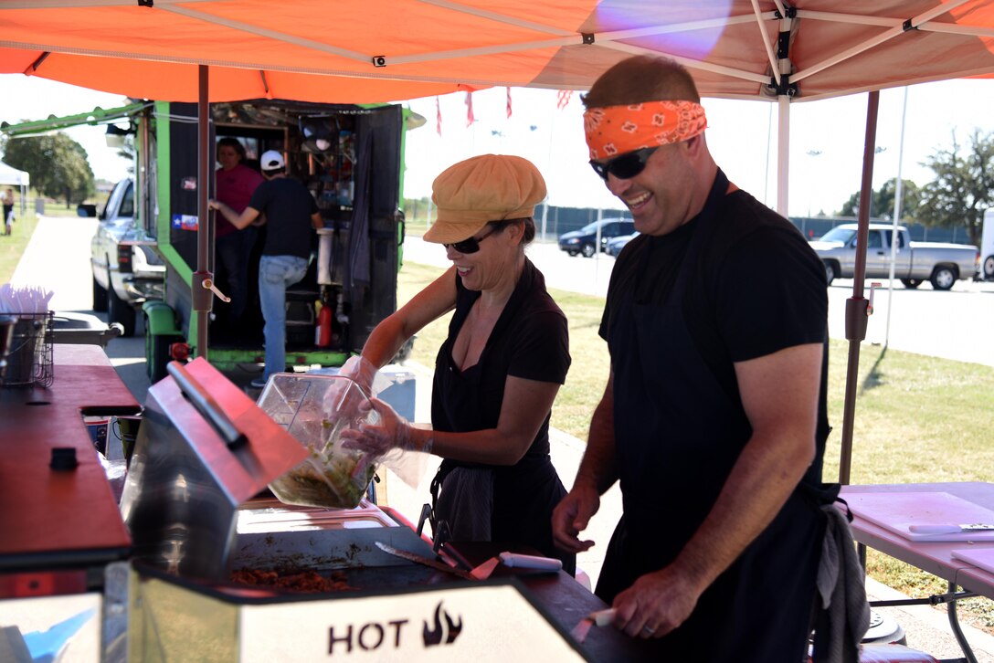 U.S. Air Force Master Sgt. Blake Ferguson, 17th Force Supoort Squadron airmen leadership school commandant, and Marla Ferguson, food vendor, cook Korean tacos during the Make Goodfellow Great Trucktoberfest event at the parade grounds on Goodfellow Air Force Base, Texas, Oct. 21, 2016. Trucktoberfest was an initiative to get individuals interested in joining Goodfellow clubs. (U.S. Air Force photo by Senior Airman Joshua Edwards/Released)