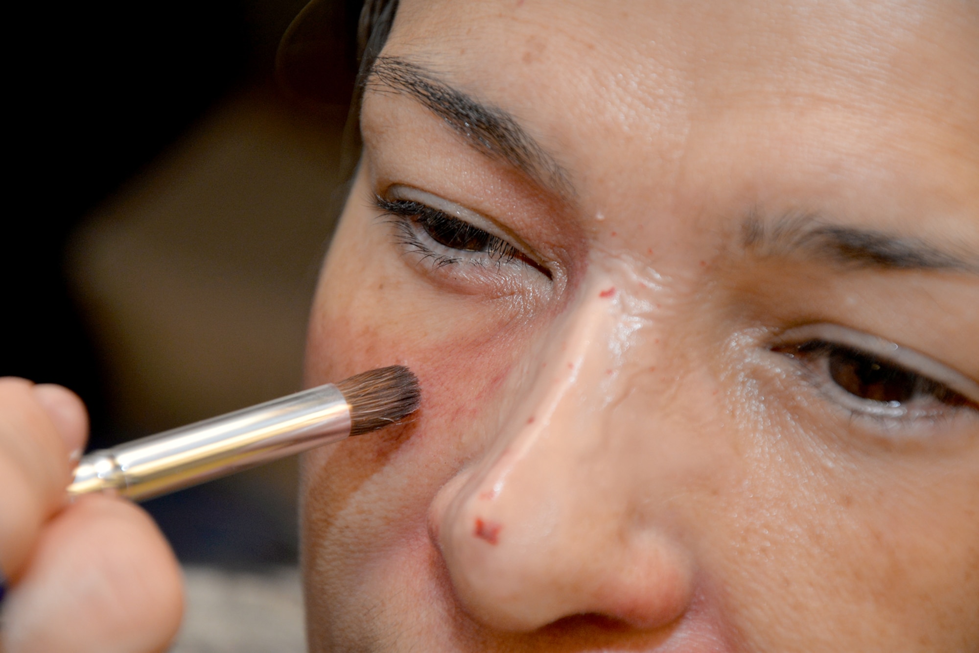 Sandra Maldanado, 17th Mission Support Group financial and computer support specialist, has moulage applied to her face during the Black Eye Campaign at Goodfellow Air Force Base, Texas, Oct. 21, 2016. Participants received mock black eyes to raise awareness of domestic abuse. (U.S. Air Force photo by Airman 1st Class Randall Moose/Released)