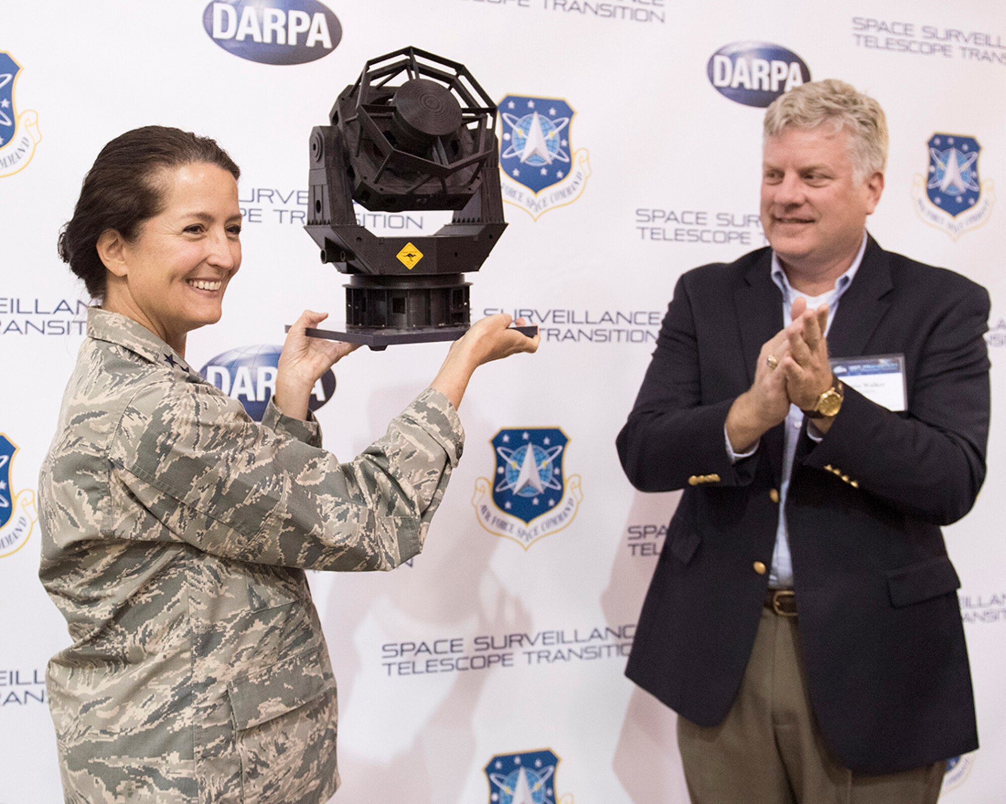 WHITE SANDS MISSILE RANGE, N.M. - Maj. Gen. Nina Armagno, Air Force Space Command director of strategic plans, programs, requirements and analysis, receives a model of the Space Surveillance Telescope from Dr. Steven Walker, Deputy Director of Defense Advanced Research Projects Agency, at an event near White Sands Missile Range, New Mexico, Oct. 18, 2016. SST has discovered 3,600 new asteroids, four comets and 69 near-Earth objects. (Courtesy photo)