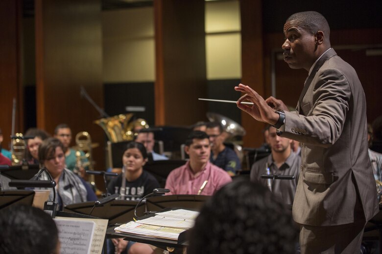 Gunnery Sgt. Justin Hauser, enlisted conductor of Marine Corps Band New Orleans, rehearses with his Marines and students from the Conservatorio de Musica de Puerto Rico, in preparation for the Marine Forces Reserve Centennial celebration concert Oct. 18, 2016. The Marine Corps Reserve is commemorating 100 years of rich history, heritage, espirit-de-corps, and a bond with Puerto Rico and communities across the U.S. The celebration recognizes the Reserve's essential role as a crisis response force and expeditionary force in readiness, constantly preparing to augment the active component. (U.S. Marine photo by Sgt. Sara Graham/Released)