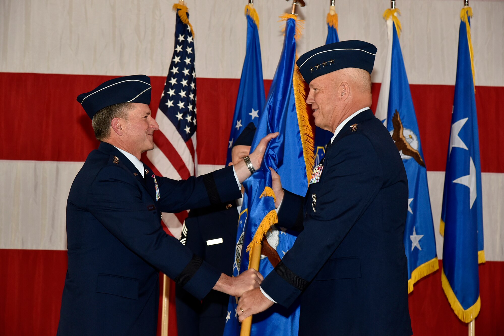 From left, Air Force Chief of Staff Gen. David L. Goldfein passes the guidon of Air Force Space Command, to Gen. John Raymond at Peterson Air Force Base, Colo., Oct. 25, 2016. Raymond was previously the Deputy Chief of Staff for Operations, Headquarters Air Force. (U.S. Air Force Photo/Craig Denton)