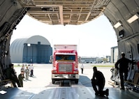 Chris Hinkle, Maryland Task Force 1 logistics specialist from the Montgomery County Urban Search & Rescue Team, slowly drives an International truck with a 53-foot trailer into the cargo compartment of a C-5M Super Galaxy Oct. 18, 2016, on Dover Air Force Base, Del. Loadmasters from the 9th Airlift Squadron guided Hinkle and the 60,000-pound truck and trailer up the DOMOPS Airlift Modular Approach Shoring ramps and into the cargo compartment. (U.S. Air Force photo by Roland Balik)