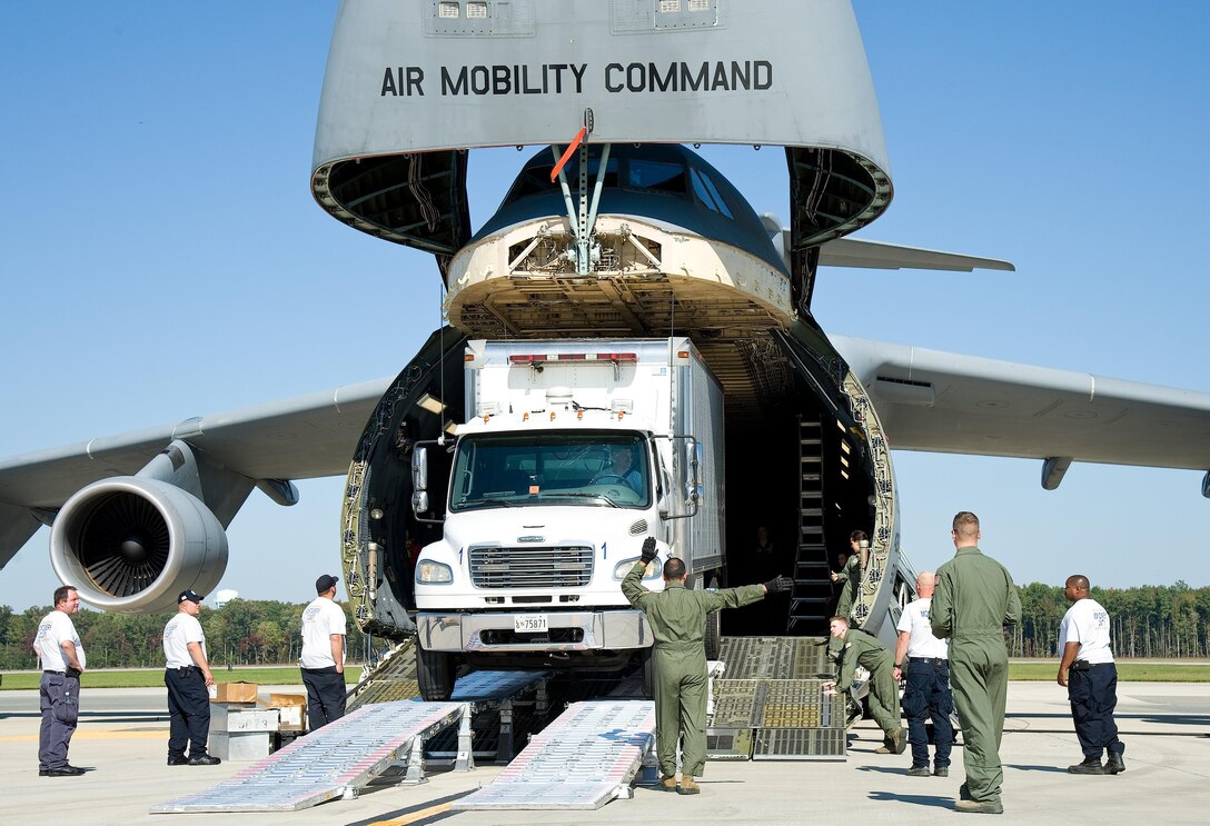 Tech. Sgt. John Crowe, 9th Airlift Squadron loadmaster, marshals Bradley Wilt, Maryland Task Force 1 logistics specialist from the Montgomery County’s Urban Search & Rescue Team, as he drives a Freightliner truck backwards into the cargo compartment of a C-5M Super Galaxy Oct. 18, 2016, on Dover Air Force Base, Del. Wilt backed the 21,960-pound truck into the cargo compartment using the loading ramp system known as DAMAS 26K which stands for DOMOPS Airlift Modular Approach Shoring. The 900-pound DAMAS 26K can be set up by two to three individuals in 14 minutes, replacing an antiquated 6,000-pound wood shoring kit that required a team of personnel and a forklift to set up. (U.S. Air Force photo by Roland Balik)