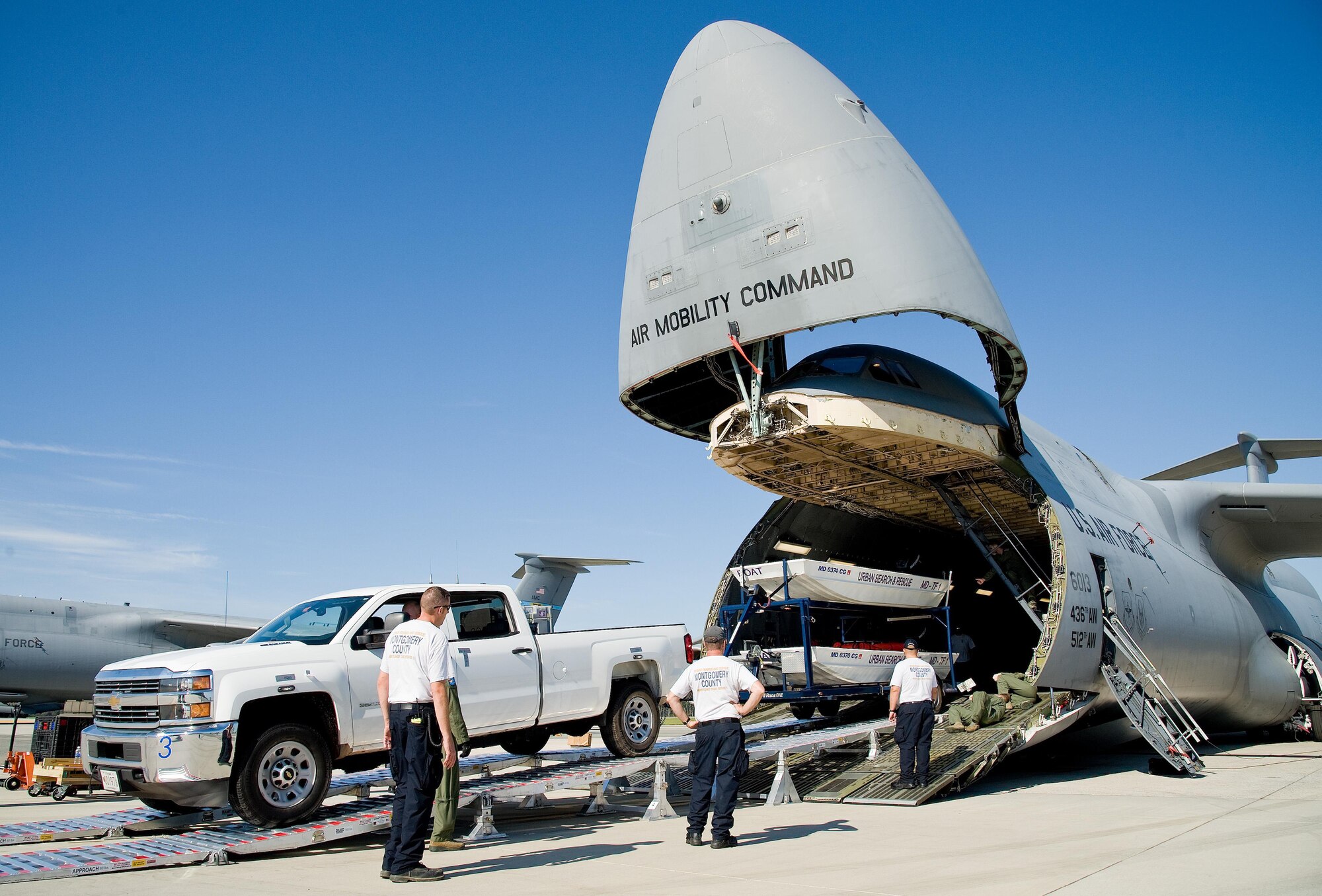 Mike Crawford, Maryland Task Force 1 logistics manager for the Montgomery County Urban Search & Rescue Team, backs a Chevy HD 3500 pickup truck and boat trailer up the loading ramp and into the cargo compartment of a C-5M Super Galaxy Oct. 18, 2016, on Dover Air Force Base, Del. Loadmasters from the 9th Airlift Squadron guided Crawford up the DOMOPS Airlift Modular Approach Shoring ramps, also known as DAMAS 26K. (U.S. Air Force photo by Roland Balik)