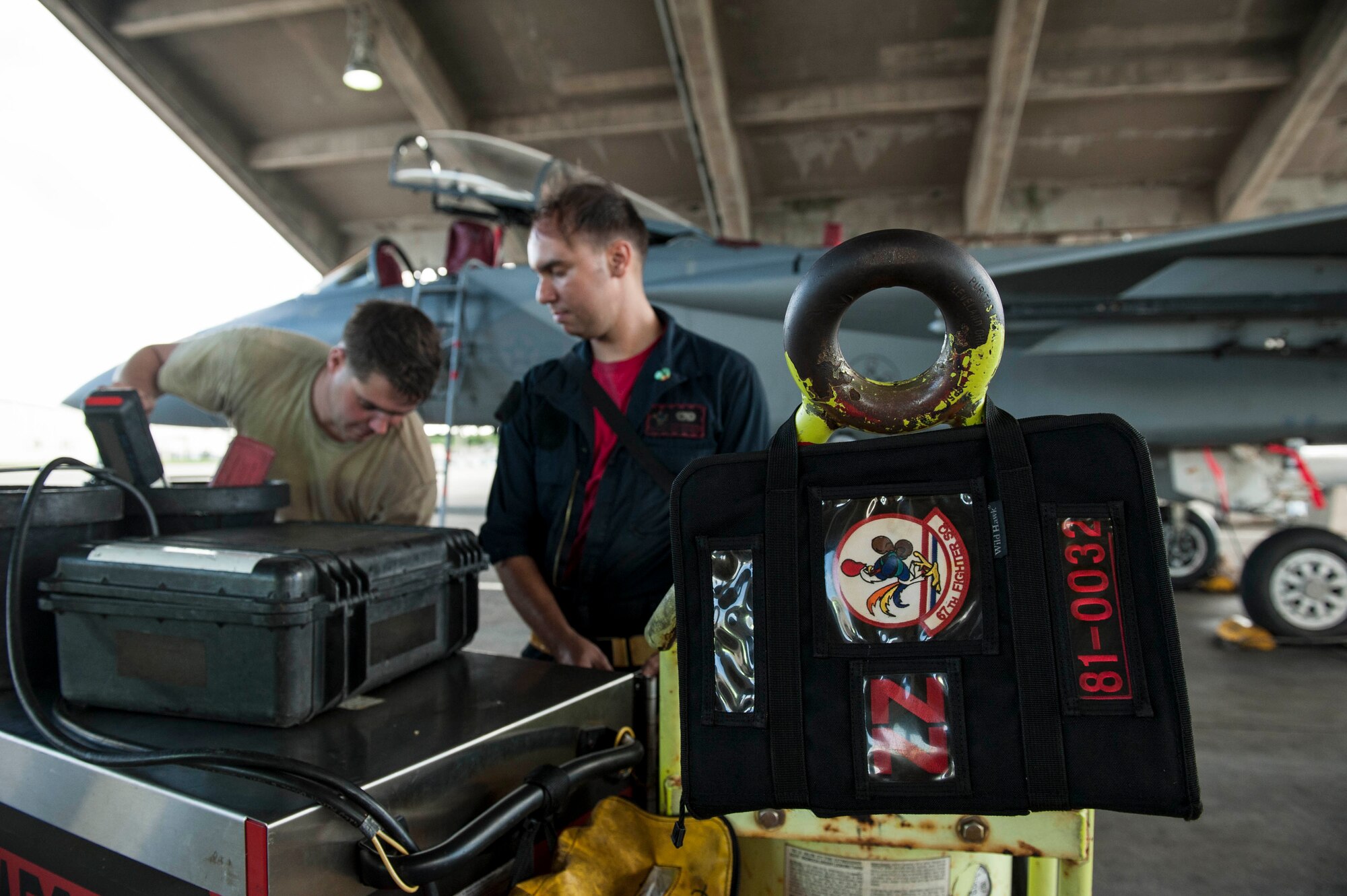 U.S. Air Force Staff Sgt. Carl Petmecky and Senior Airman Alexander Reyes, 67th Aircraft Maintenance Unit crew chiefs, secure tools and equipment during a shift change Oct. 21, 2016, at Kadena Air Base, Japan. Petmecky and Reyes performed maintenance on an F-15 Eagle undergoing an engine swap. (U.S. Air Force photo by Senior Airman Peter Reft/Released)
