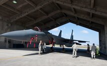 Airmen from the 18th Aircraft Maintenance Squadron prepare for a quarterly weapons load competition Oct. 24, 2016, at Kadena Air Base, Japan. To signal the start of the competition, an evaluator called the teams to attention and presented them with a time limit of 35 minutes to load missiles onto an F-15 Eagle. (U.S. Air Force photo by Senior Airman Lynette M. Rolen/Released)