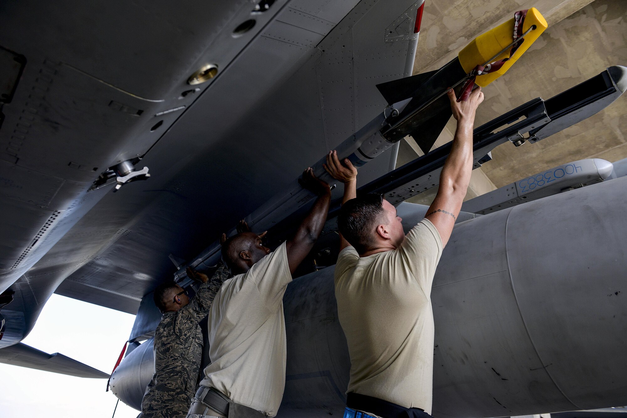 Weapons load crew team members from the 44th Aircraft Maintenance Unit work together to lift an AIM-9L/M Sidewinder missile onto an LAU-128 missile rail launcher during a quarterly weapons load competition Oct. 24, 2016, at Kadena Air Base, Japan. Air Force weapons load crew competitions showcase the efficiency of load crew teams to safely, reliably and properly arm an F-15 within time constraints. (U.S. Air Force photo by Naoto Anazawa/Released)
