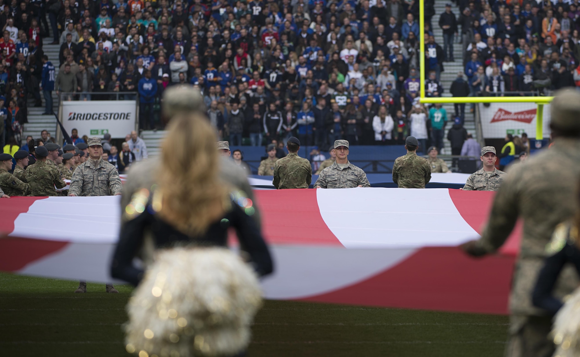 Airmen from Royal Air Force Lakenheath hold the U.S. flag during a pre-game ceremony before the Los Angeles Rams - New York Giants Football game in London, England Oct 23. The game was the second of three international NFL games that will be played this season in London. (U.S. Air Force photo/Staff Sgt. Emerson Nuñez)