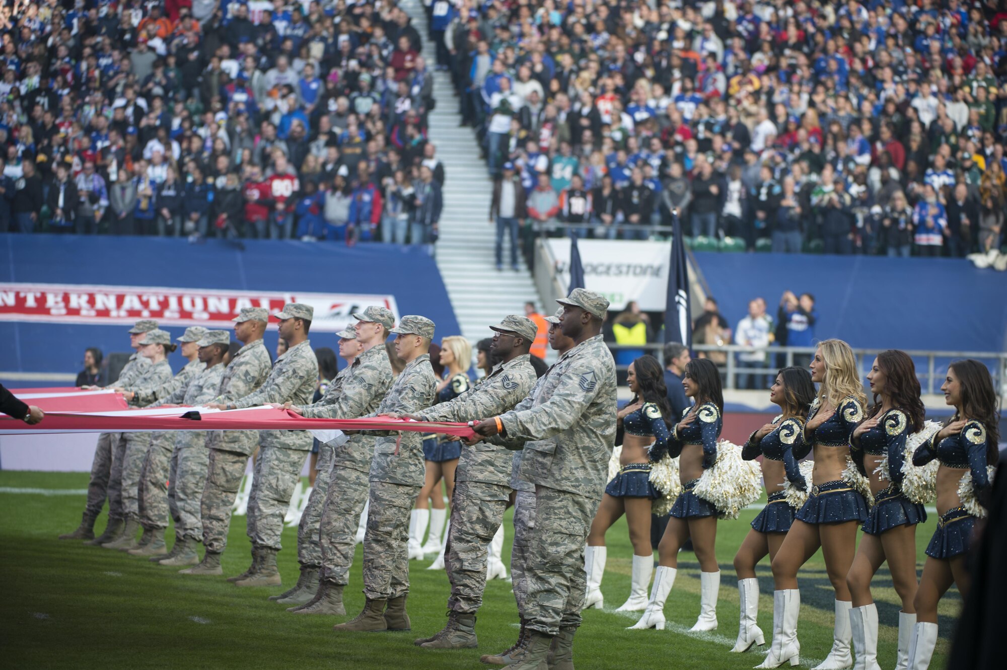Airmen from Royal Air Force Lakenheath hold the U.S. flag during the U.S. National Anthem as part of pre-game ceremony before the Los Angeles Rams - New York Giants Football game in London, England Oct 23. As part of the ceremony, the 48th Fighter Wing Airmen presented a U.S. Flag alongside a U.K. flag presented by British service members as a sign of the continued cooperation between U.S. visiting forces and their U.K. hosts. (U.S. Air Force photo/Staff Sgt. Emerson Nuñez)