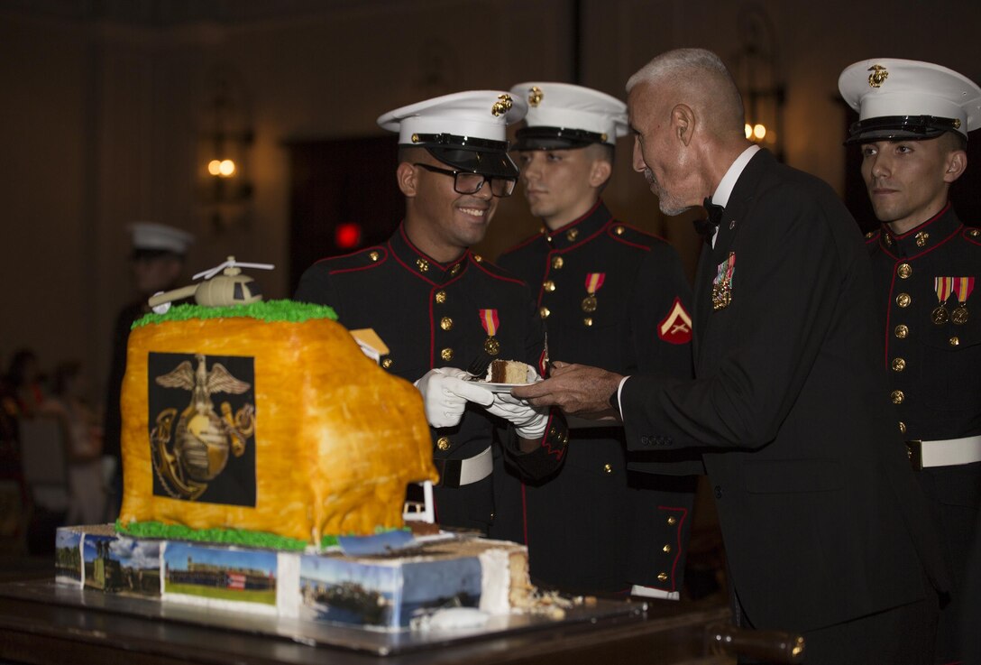 Retired Sgt. Maj. Jose Santiago, the oldest Marine present, passes  a piece of cake to Pfc. Alex Falcon, the youngest Marine present, at the Detachment 1, Landing Support Company, Combat Logistics Regiment 45, 4th Marine Logistics Group, 241st Marine Corps Birthday Ball celebration in Rio Grande, Puerto Rico, Oct. 22, 2016. The Reserve Marines are celebrating the 241st birthday as well as the Marine Corps Reserve Centennial anniversary. For the past week they have joined Marine Corps Band New Orleans to commemorate 100 years of rich history, heritage, espirit-de-corps, and a bond with not only Puerto Rico but with communities across the U.S. (U.S. Marine photo by Sgt. Sara Graham/Released)