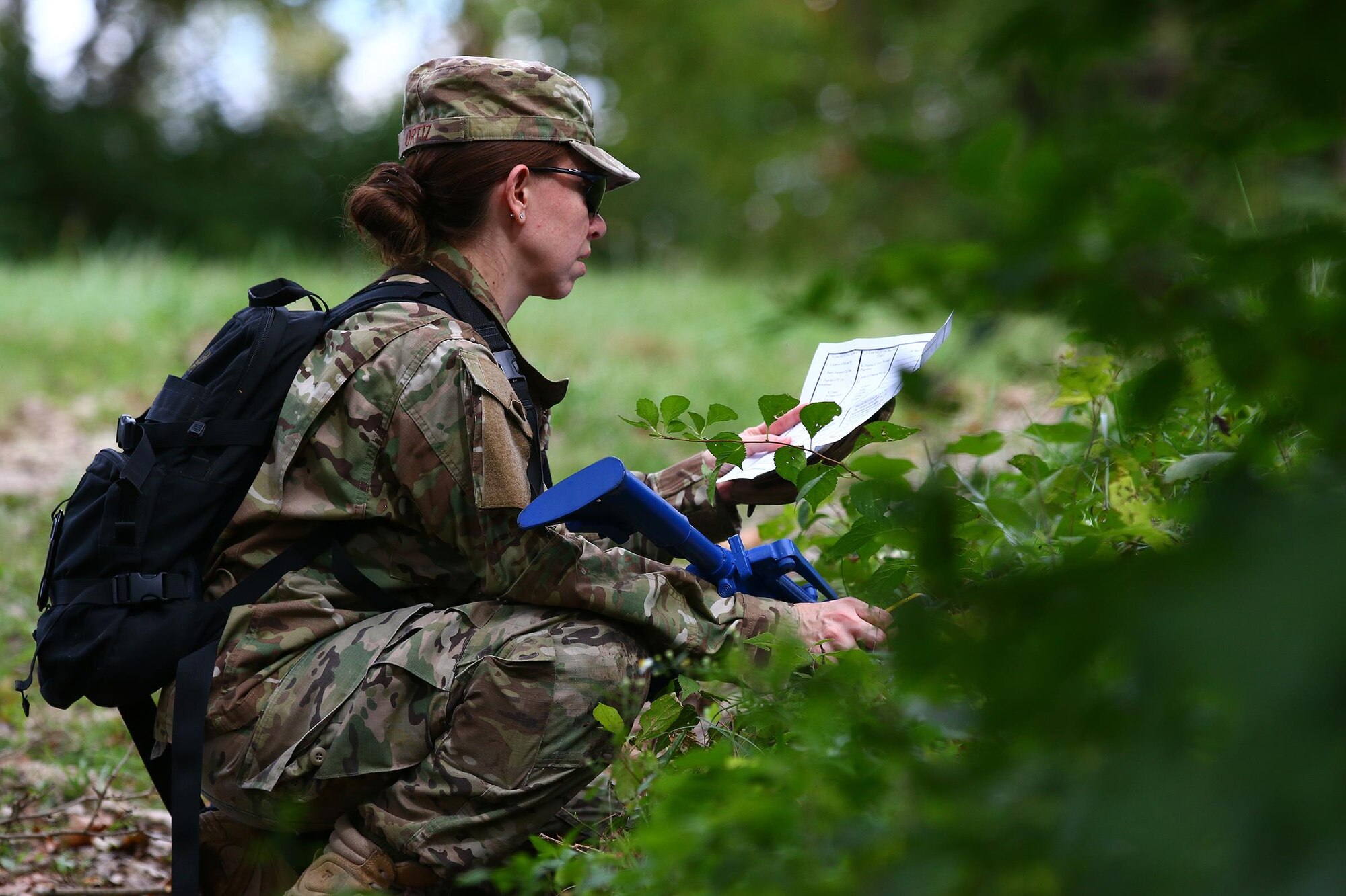 Senior Airman Angelica Ortiz, 445th Security Forces Squadron, takes the opportunity to review her notes while taking cover during a Land navigation training exercise held here during the Oct. 2, 2016 unit training assembly. Security forces members must accurately and effectively perform their tactical capabilities to defend against threats. (U.S. Air Force photo /Tech. Sgt. Patrick O’Reilly)
