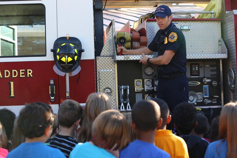 Edward Hudson explains the functions of a ladder truck to students at W.J. Gurganus Elementary School in Havelock, N.C., Oct. 20, 2016. The Cherry Point Fire and Emergency Services Department visited the school to demonstrate what to do in fire emergencies and how to prevent them. The students also learned about the equipment firefighters use every day to complete their mission. Hudson is the fire captain with the Cherry Point Fire and Emergency Services Department. (U.S. Marine Corps photo by Lance Cpl. Mackenzie Gibson/Released)