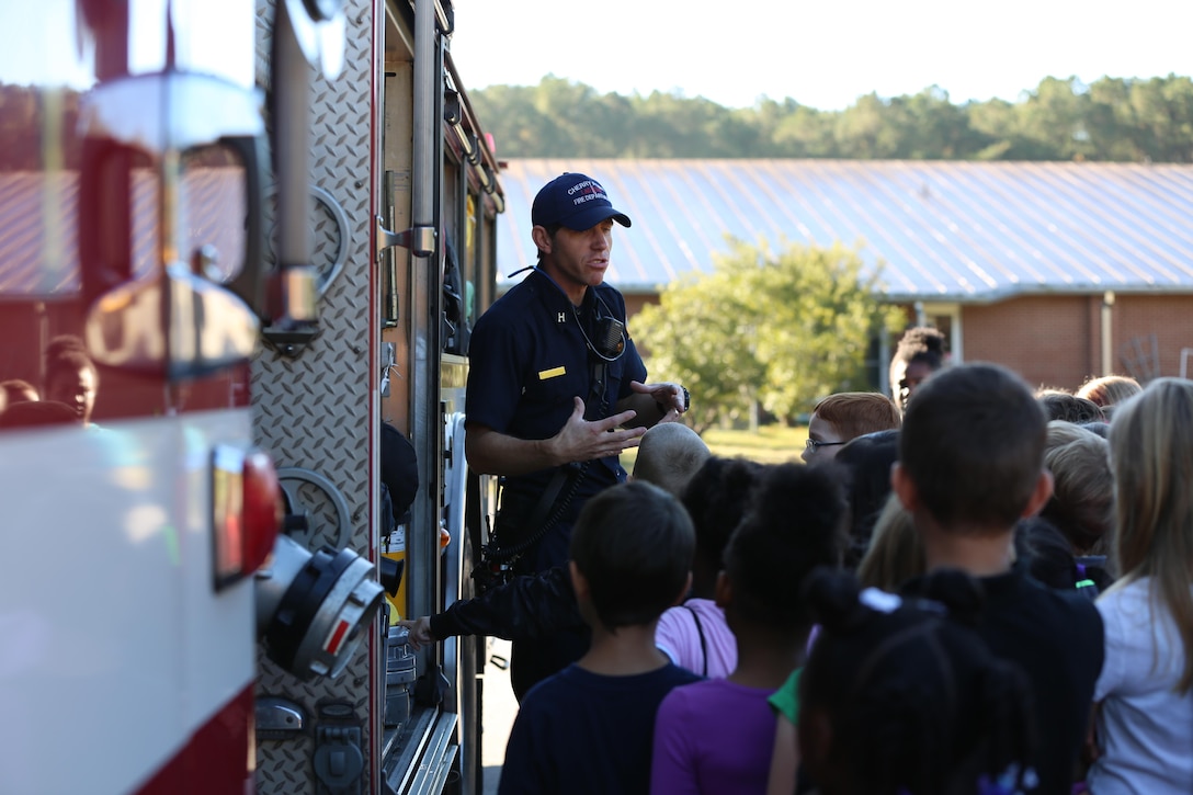 Edward Hudson explains the functions of a ladder truck to students at W.J. Gurganus Elementary School in Havelock, N.C., Oct. 20, 2016. The Cherry Point Fire and Emergency Services Department visited the school to demonstrate what to do in fire emergencies and how to prevent them. The students also learned about the equipment firefighters use every day to complete their mission. Hudson is the fire captain with the Cherry Point Fire and Emergency Services Department. (U.S. Marine Corps photo by Lance Cpl. Mackenzie Gibson/Released)