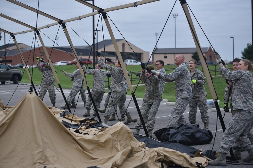 Members of the 932nd Aeromedical Staging Squadron work together to lift the center of the massive deployment tent during a recent unit training assembly.  (U.S. Air Force photo by Tech. Sgt. Christopher Parr)