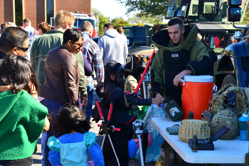 U.S. Air Force Airman 1st Class Keldan Doheney, 633rd Civil Engineer Squadron Explosive Ordinance Disposal team member, hands out candy during the Trunk-or-Treat event at Joint Base Langley-Eustis, Va., Oct. 22, 2016. This year's event was supported by 26 units who decorated 49 trunks. (U.S. Air Force photo by Airman 1st Class Tristan Biese)