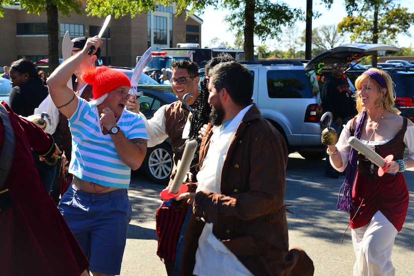 Members of the 15th Intelligence Squadron run around dressed as children themed characters during the Trunk-or-Treat event at Joint Base Langley-Eustis, Va., Oct. 22, 2016. The Airman & Family Readiness Center hosts events such as the Trunk-or-Treat to build support systems within the units as well as with the community. (U.S. Air Force photo by Airman 1st Class Tristan Biese)