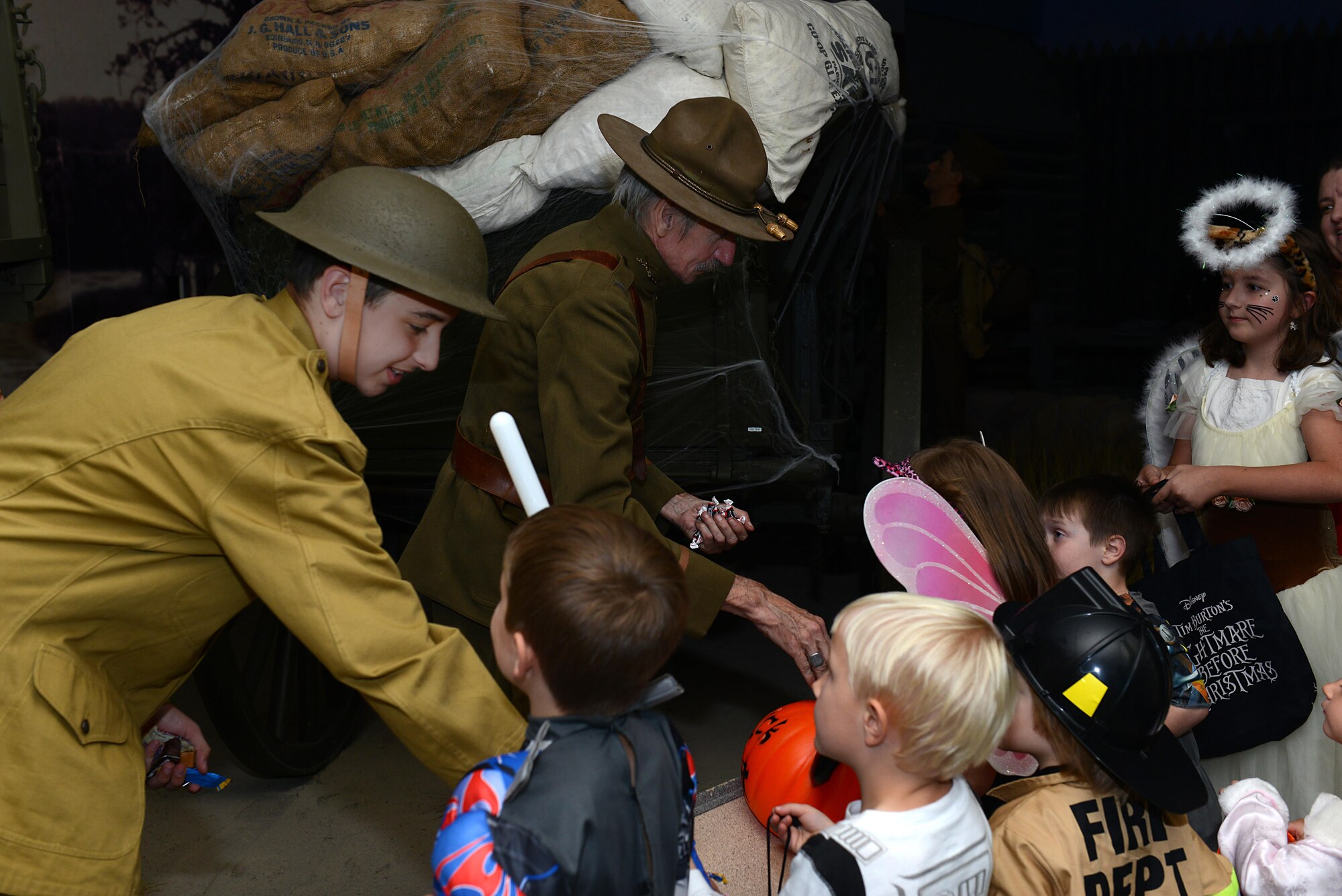 Volunteers and professional reenactors pass out candy to children at the Night at the Transportation Museum event at Joint Base Langley-Eustis, Va., Oct. 24, 2016. Actors created scenes to provide an educational experience for children during the event. (U.S. Air Force photo by Staff Sgt. Teresa J. Cleveland)