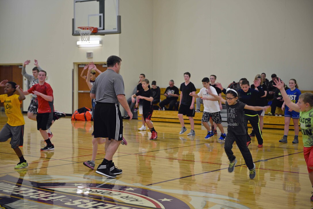 Troy Pearson, director of the Minnesota Timberwolves and Lynx Academy, conducts warm up drills at the military kids basketball camp Oct. 22.  
