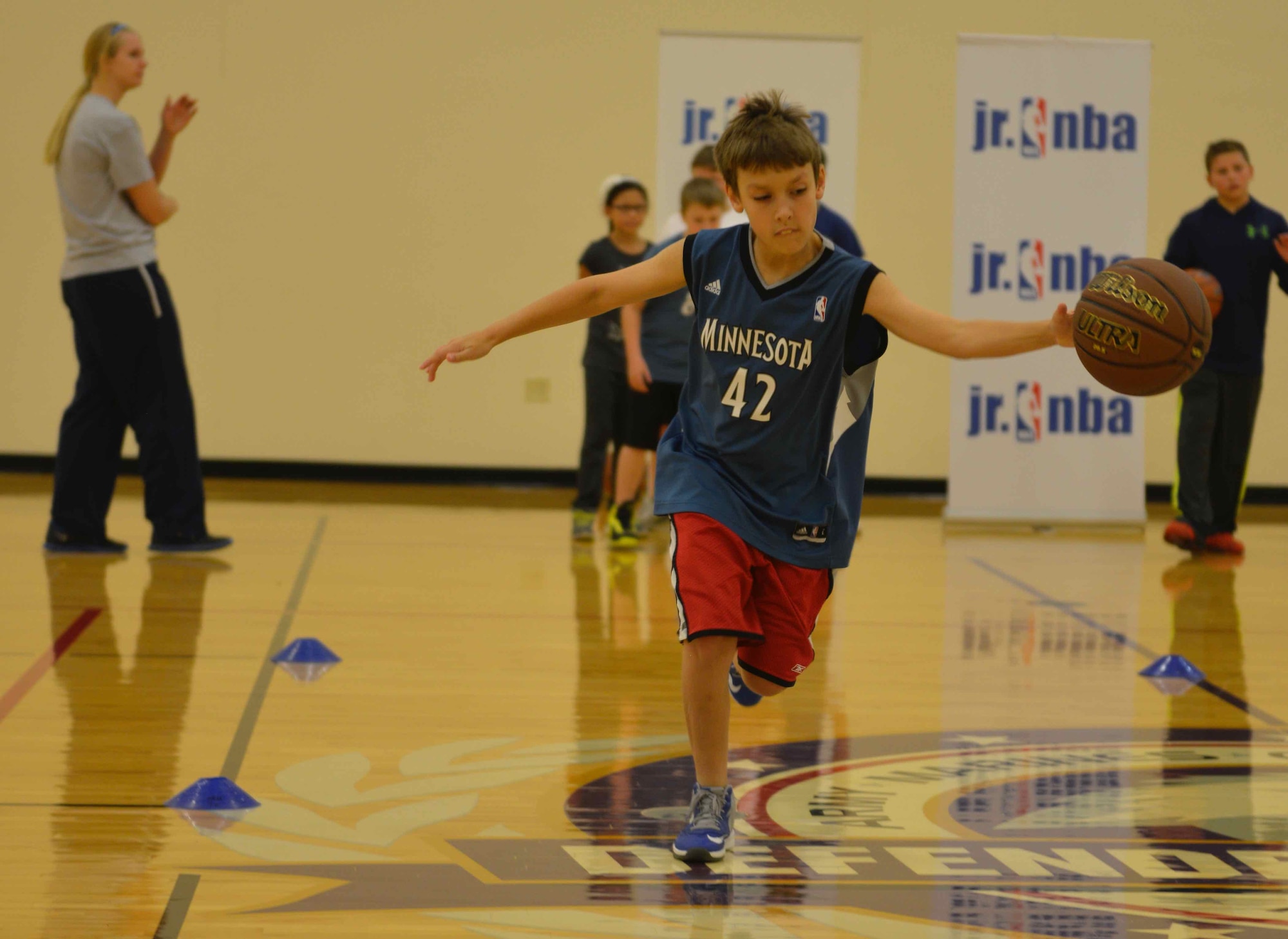 Stephanie Sension (left) conducts ball handling drills at the military kids basketball clinic Oct. 22.