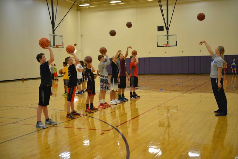 Stephanie Sension (right) conducts shooting drills at the military kids basketball clinic Oct. 22.