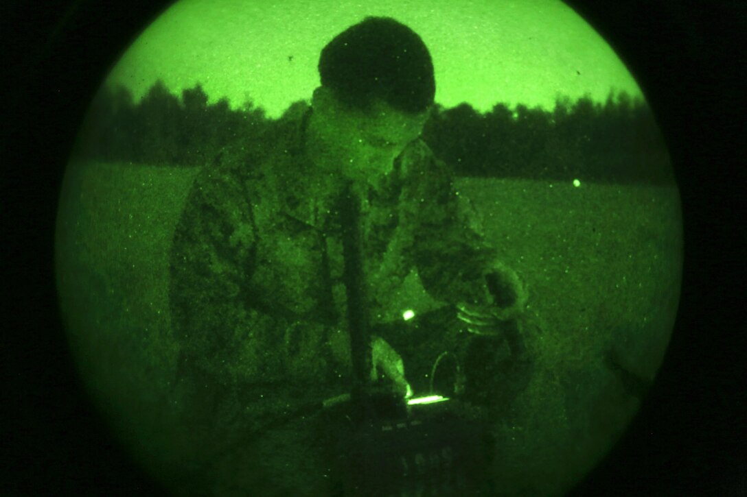 As seen through a night-vision device, Marine Corps Sgt. Samuel Hibbard sets up communication using a multiband portable radio during a helicopter support training exercise on Phoenix landing zone at Camp Lejeune, N.C., Oct. 20, 2016. Hibbard is assigned to Combat Logistics Battalion 25, 4th Marine Logistics Group. Marine Corps photo by Lance Cpl. Jack A. E. Rigsby