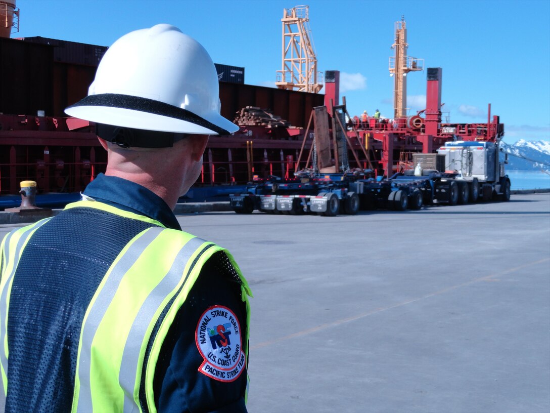 A member of the Coast Guard Pacific Strike Team, observes I-beam off-loading operations on the BBC Arizona in Valdez following the discovery of leaking oil containers aboard the ship. The Pacific Strike Team, based in Novato, Calif., is on scene augmenting Coast Guard Marine Safety Unit Valdez personnel during oversight and monitoring of the response. (Courtesy Photo)
