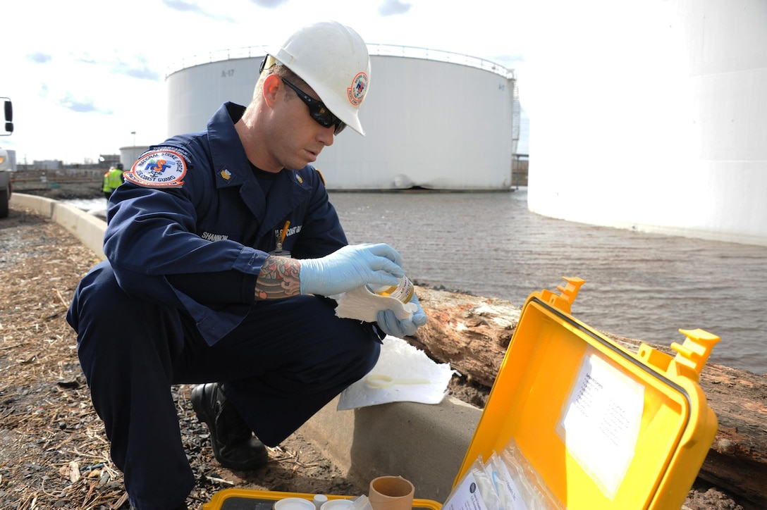 A Marine Science Technician with the Pacific Strike Team, takes a sample near a damaged tank that leaked during Hurricane Sandy at the Motiva Terminal in Sewaren, N.J. Responders are working to remove contained pockets of oil that leaked from the facility during Hurricane Sandy utilizing skimmers, vacuum trucks, absorbent pads and boom. (U.S. Coast Guard photo by Petty Officer 2nd Class Jaclyn Young)