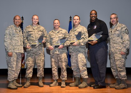 Col. Jimmy Canlas, left, 437th Airlift Wing commander, and Chief Master Sgt. Kristopher Berg, 437th AW command chief, right, stand with the 437th AW third quarter award winners during a ceremony at the Joint Base Charleston Theater Oct. 25. The awardees, from left to right, are:  Senior Airman Ron Vorndran, Master Sgt. Robert Pickel, Tech. Sgt. Jason Mark and Mr. Nathan Watts. The quarterly awards recognize outstanding Airmen, NCOs, senior NCOs, company grade officers and civilians for their hard work and dedication.