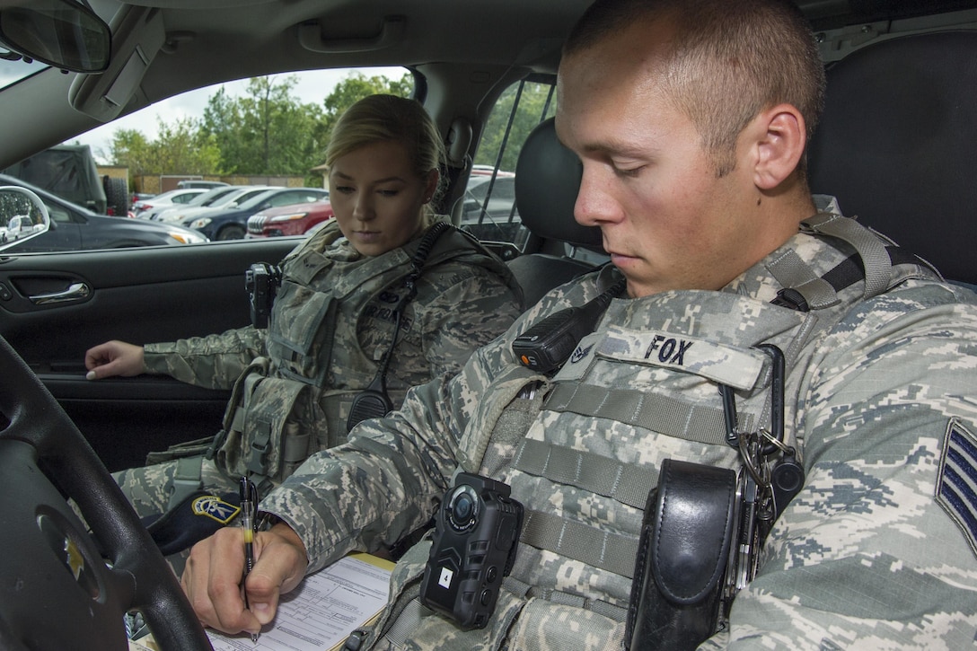 Staff Sgt. Sawyer Fox, right, and Airman 1st Class Sarah Shepherd, left, 11th Security Forces Squadron response force leaders, record information in a notebook during a patrol at Joint Base Andrews, Md., Oct. 4, 2016. JBA security forces defenders will be wearing the products for a period of six months as part of a test to determine which kind of camera to use throughout the Air Force. One of the main goals during the process is to disperse the new equipment information throughout the community to ensure they feel safe and aware. (U.S. Air Force photo by Senior Airman Jordyn Fetter)