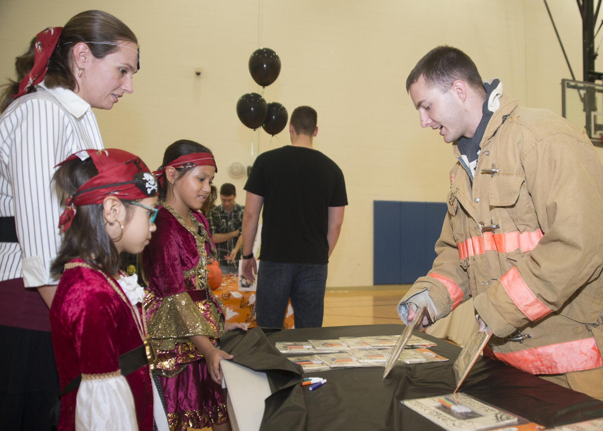 Staff Sgt. Trever Leabo, 436th Civil Engineer Squadron firefighter, gives picture frames to families with deployed members during the Deployed Families Dinner Oct. 20, 2016, at the Youth Center on Dover Air Force Base, Del. Leabo and many others volunteered their time to give back to families and spouses of deployed Airmen. (U.S. Air Force photo by Staff Sgt. Jared Duhon)  