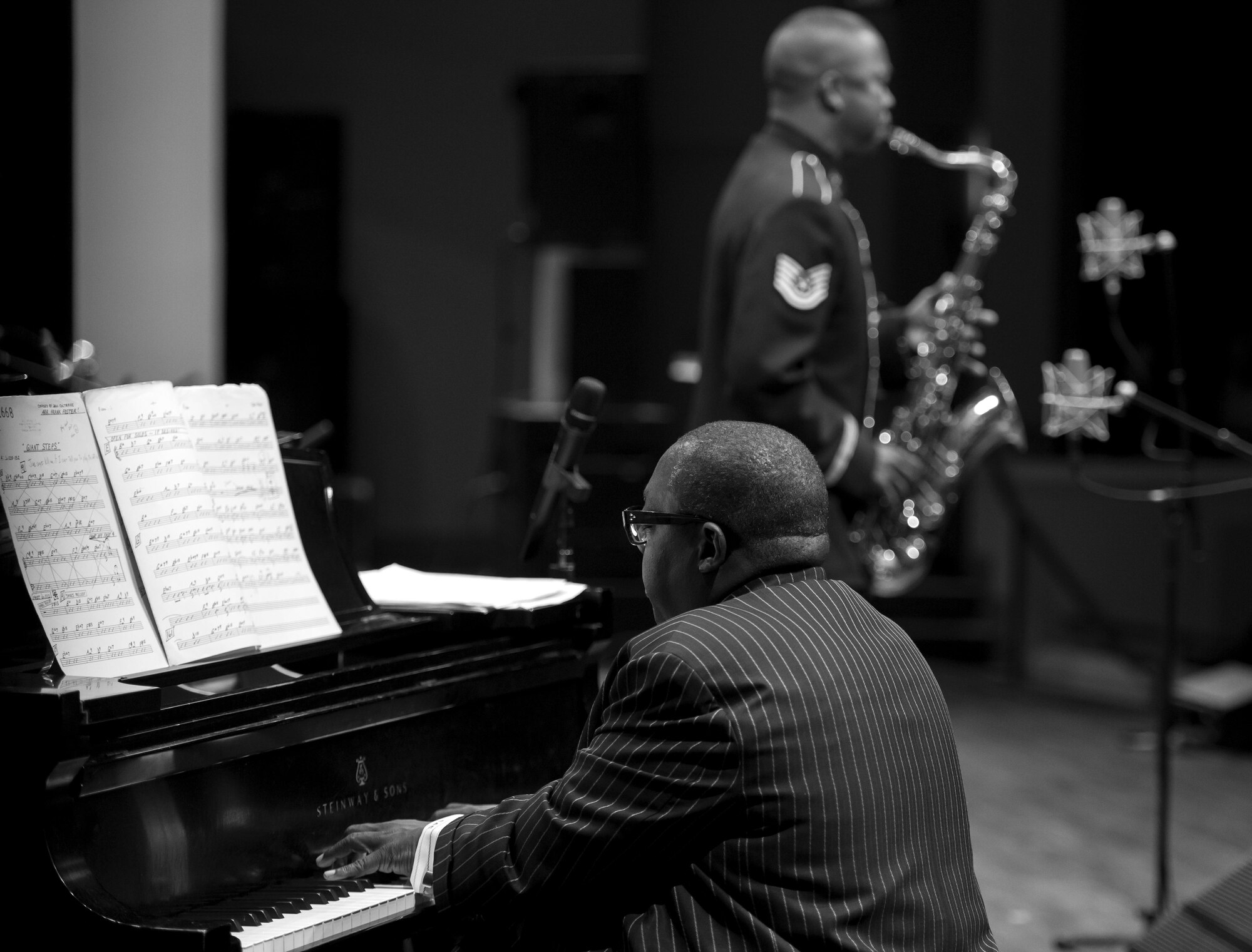 Cyrus Chestnut, jazz pianist, plays the piano alongside Tech. Sgt. Grant Langford, U.S. Air Force Band's Airmen of Note tenor saxophonist, during the 2016 Jazz Heritage Series performance at the Rachel M. Schlesinger Concert Hall in Alexandria, Va., Oct. 21, 2016. Chestnut, who has worked with many big bands, including the Lincoln Center Jazz Orchestra and the Dizzy Gillespie All-Star Big Band, was the featured guest during this series performance. The Airmen of Note established the Jazz Heritage Series in 1990 and each year they perform with legendary icons of jazz. (U.S. Air Force photo by Airman Gabrielle Spalding)